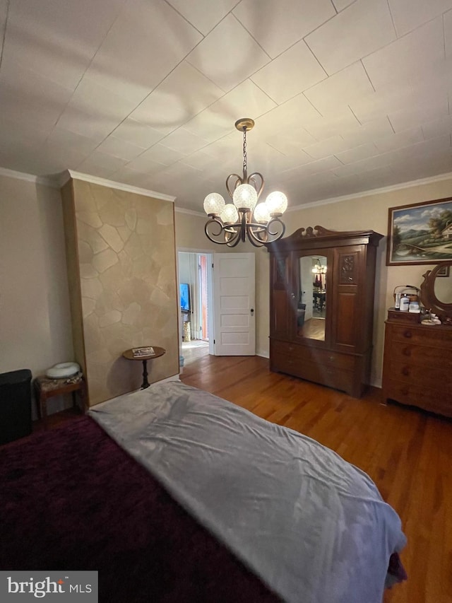 bedroom with hardwood / wood-style flooring, ornamental molding, and a chandelier