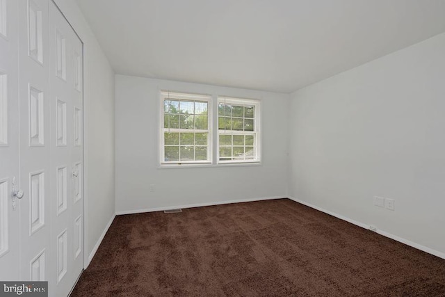 empty room featuring dark carpet