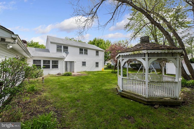 back of property with a gazebo and a yard