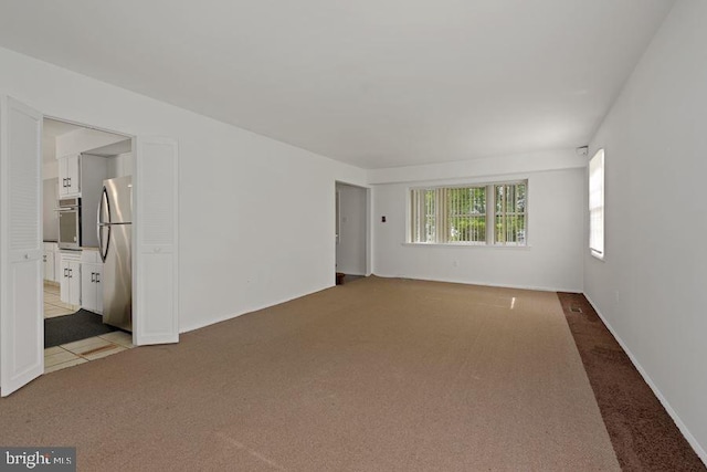 unfurnished room featuring light carpet