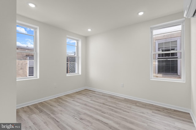 empty room featuring light hardwood / wood-style floors and a wall mounted AC