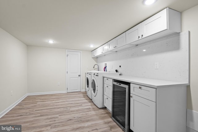 laundry area with washing machine and dryer, light hardwood / wood-style flooring, and wine cooler