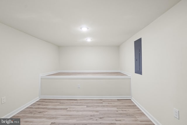 empty room with electric panel and light hardwood / wood-style flooring