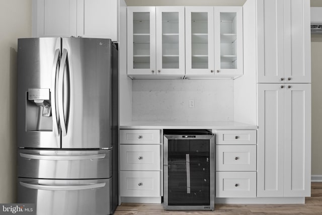 kitchen featuring white cabinetry, beverage cooler, and stainless steel refrigerator with ice dispenser