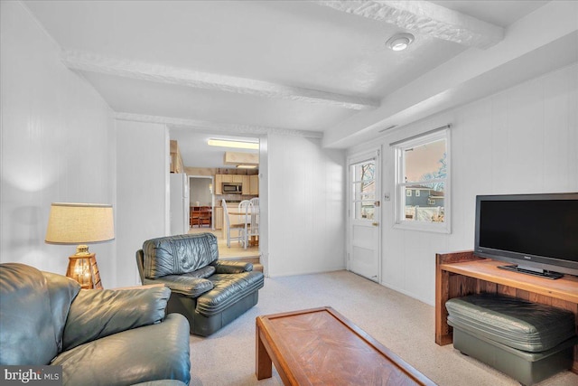 carpeted living room featuring beam ceiling