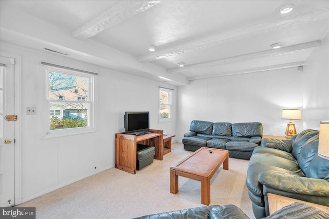 living room with beam ceiling and light carpet