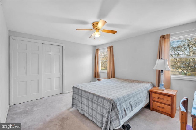 carpeted bedroom with a closet and ceiling fan