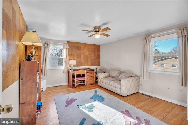 living room with ceiling fan, a healthy amount of sunlight, and light hardwood / wood-style floors