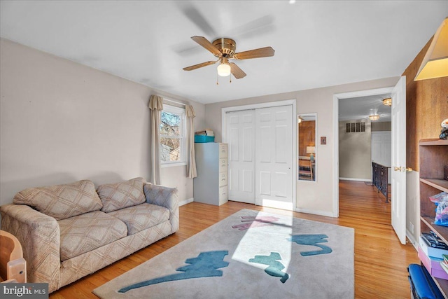 living room featuring hardwood / wood-style floors and ceiling fan