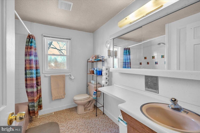 bathroom with vanity, toilet, a textured ceiling, and walk in shower