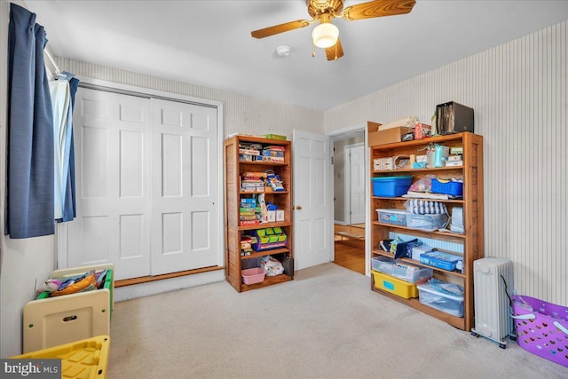 rec room featuring light carpet, radiator heating unit, and ceiling fan