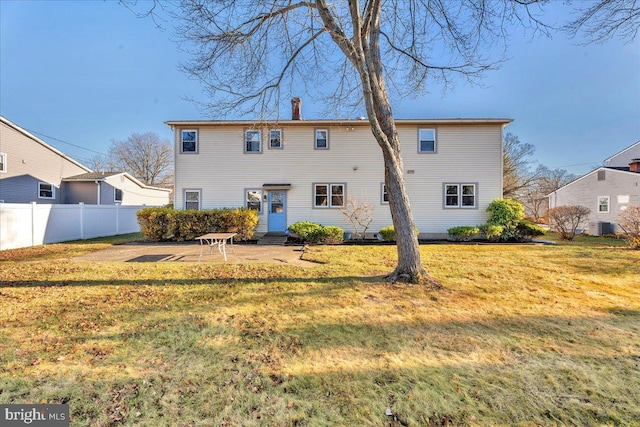 back of house with cooling unit, a patio area, and a lawn