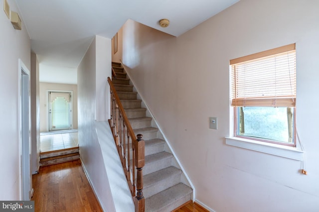 stairs featuring hardwood / wood-style floors