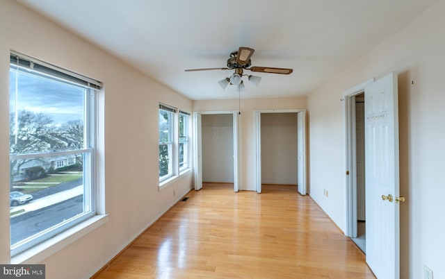 spare room with ceiling fan and light wood-type flooring