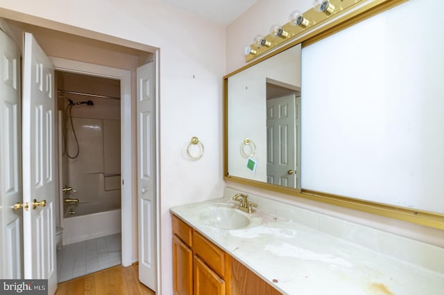 full bathroom with hardwood / wood-style flooring, vanity, shower / bathtub combination, and toilet