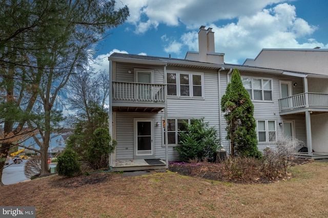 rear view of house featuring a lawn