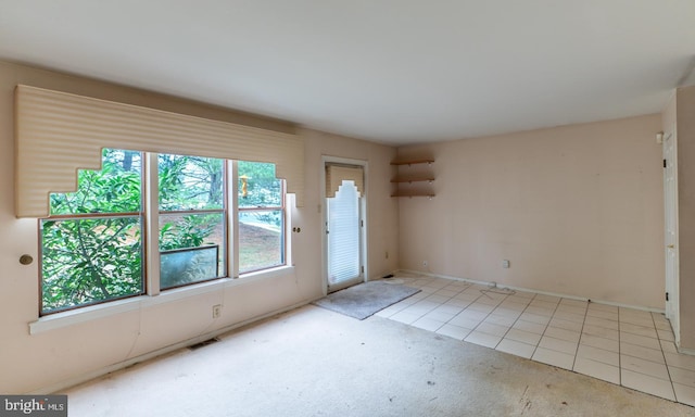 unfurnished room featuring light tile patterned floors and a wealth of natural light