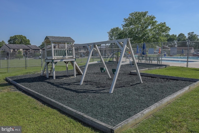 view of playground with a community pool and a yard