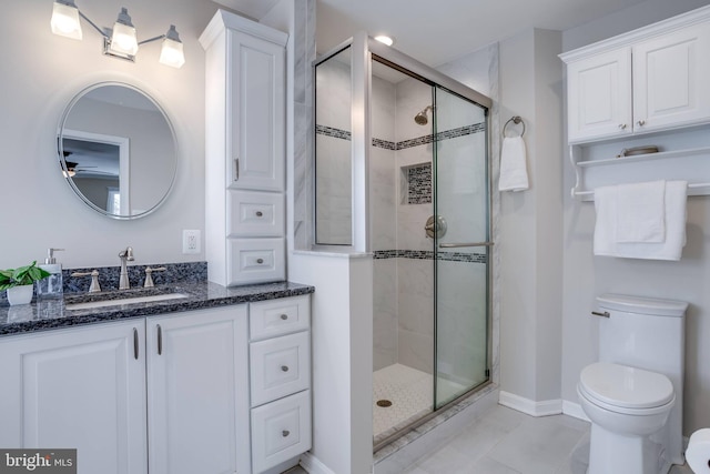 bathroom with tile patterned flooring, vanity, toilet, and a shower with door