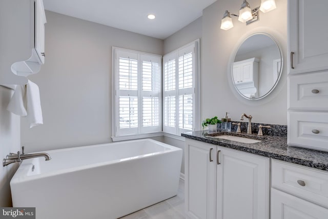 bathroom featuring vanity, tile patterned floors, and a bathing tub