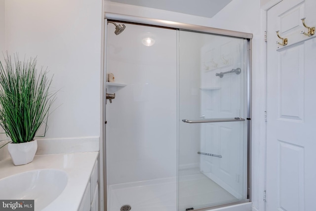 bathroom featuring an enclosed shower and sink