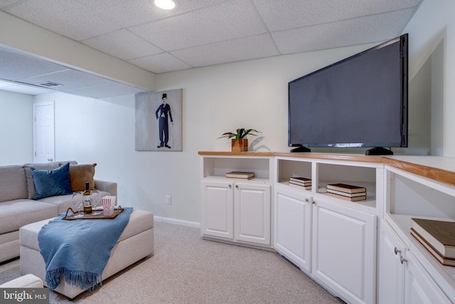 living room featuring light carpet and a drop ceiling