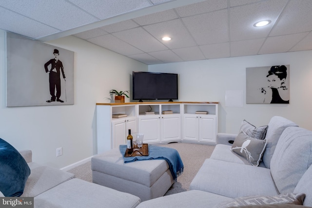 carpeted living room featuring a drop ceiling