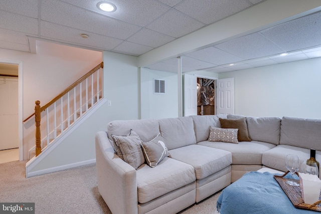 living room featuring light carpet and a drop ceiling