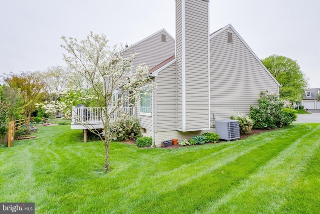 view of home's exterior featuring cooling unit, a deck, and a yard