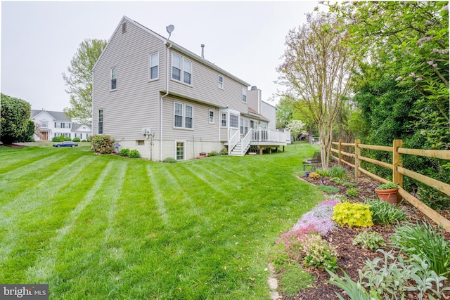 back of house featuring a yard and a wooden deck