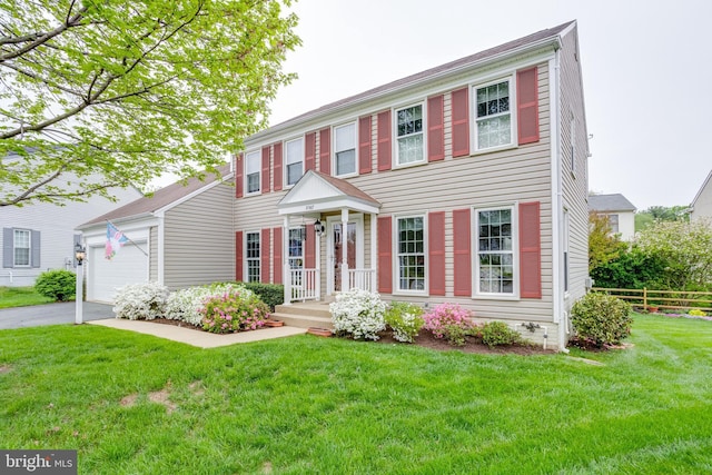 colonial-style house featuring a garage and a front yard