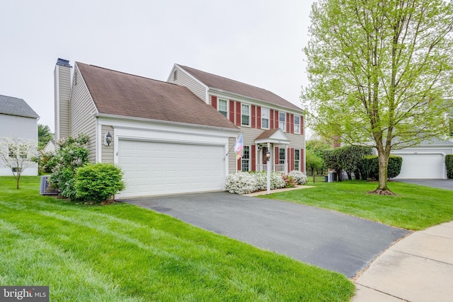 colonial-style house featuring a front lawn and a garage