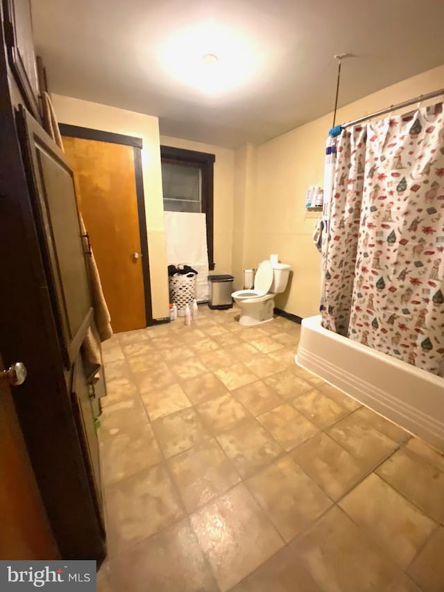 bathroom featuring shower / bath combination with curtain and toilet