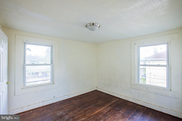 unfurnished room featuring dark hardwood / wood-style floors and a wealth of natural light