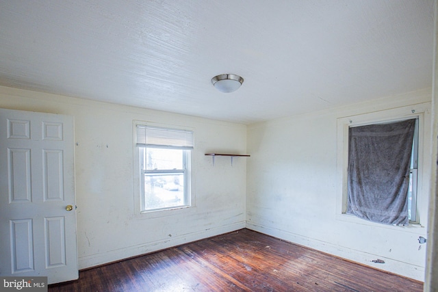 spare room with dark wood-type flooring