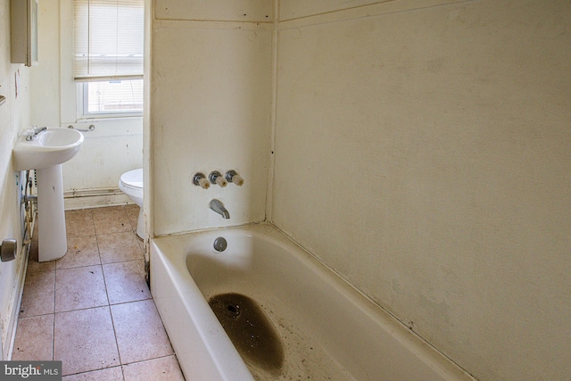 bathroom featuring tile patterned flooring, toilet, a bathtub, and sink