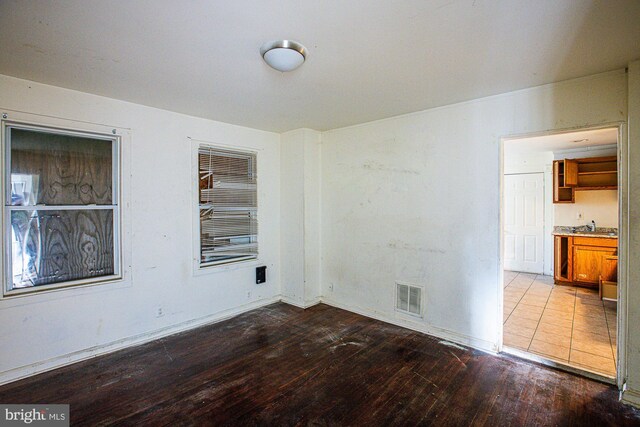 unfurnished room with hardwood / wood-style flooring and sink