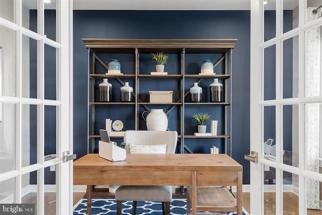 office with hardwood / wood-style flooring and french doors