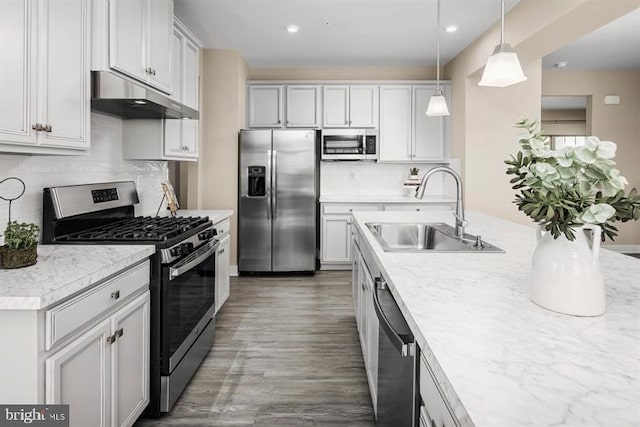 kitchen featuring white cabinets, sink, decorative backsplash, appliances with stainless steel finishes, and decorative light fixtures