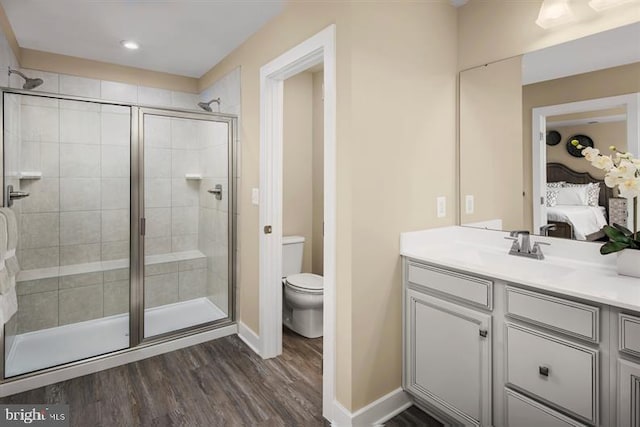 bathroom with vanity, hardwood / wood-style flooring, toilet, and a shower with door