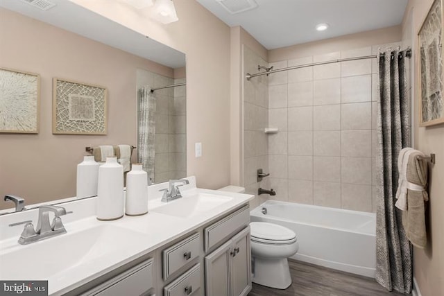 full bathroom with hardwood / wood-style floors, shower / bath combination with curtain, toilet, and vanity