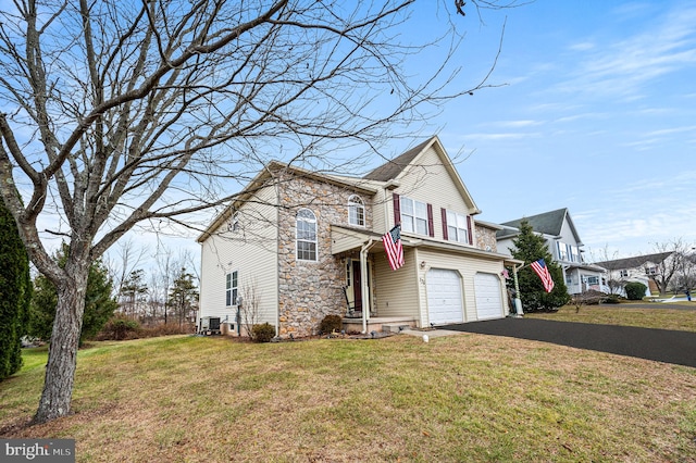 view of front property featuring a front yard, a garage, and cooling unit