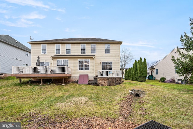 rear view of house featuring a wooden deck and a yard