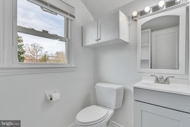 bathroom featuring vanity, toilet, and a textured ceiling