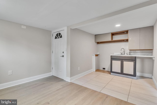 kitchen with sink, light hardwood / wood-style flooring, and gray cabinets