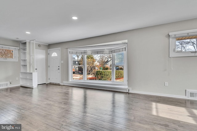 unfurnished living room with a baseboard heating unit and hardwood / wood-style flooring