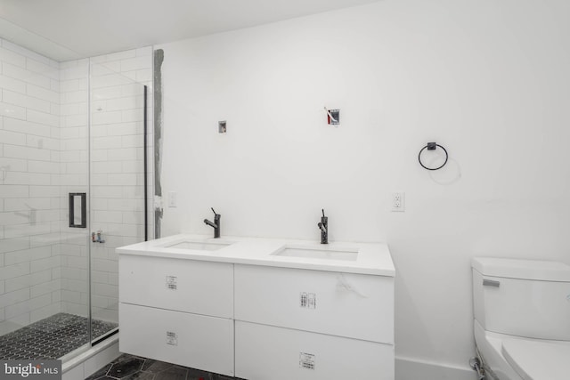 bathroom featuring a shower with door, vanity, and toilet