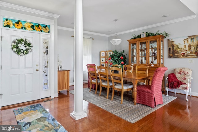 dining room with wood-type flooring, ornamental molding, and ornate columns