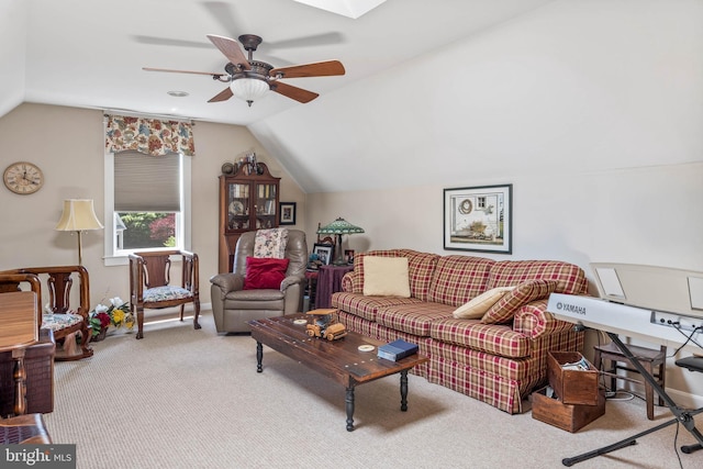 living room featuring light carpet, lofted ceiling with skylight, and ceiling fan