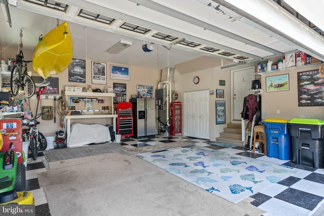 garage with stainless steel fridge with ice dispenser